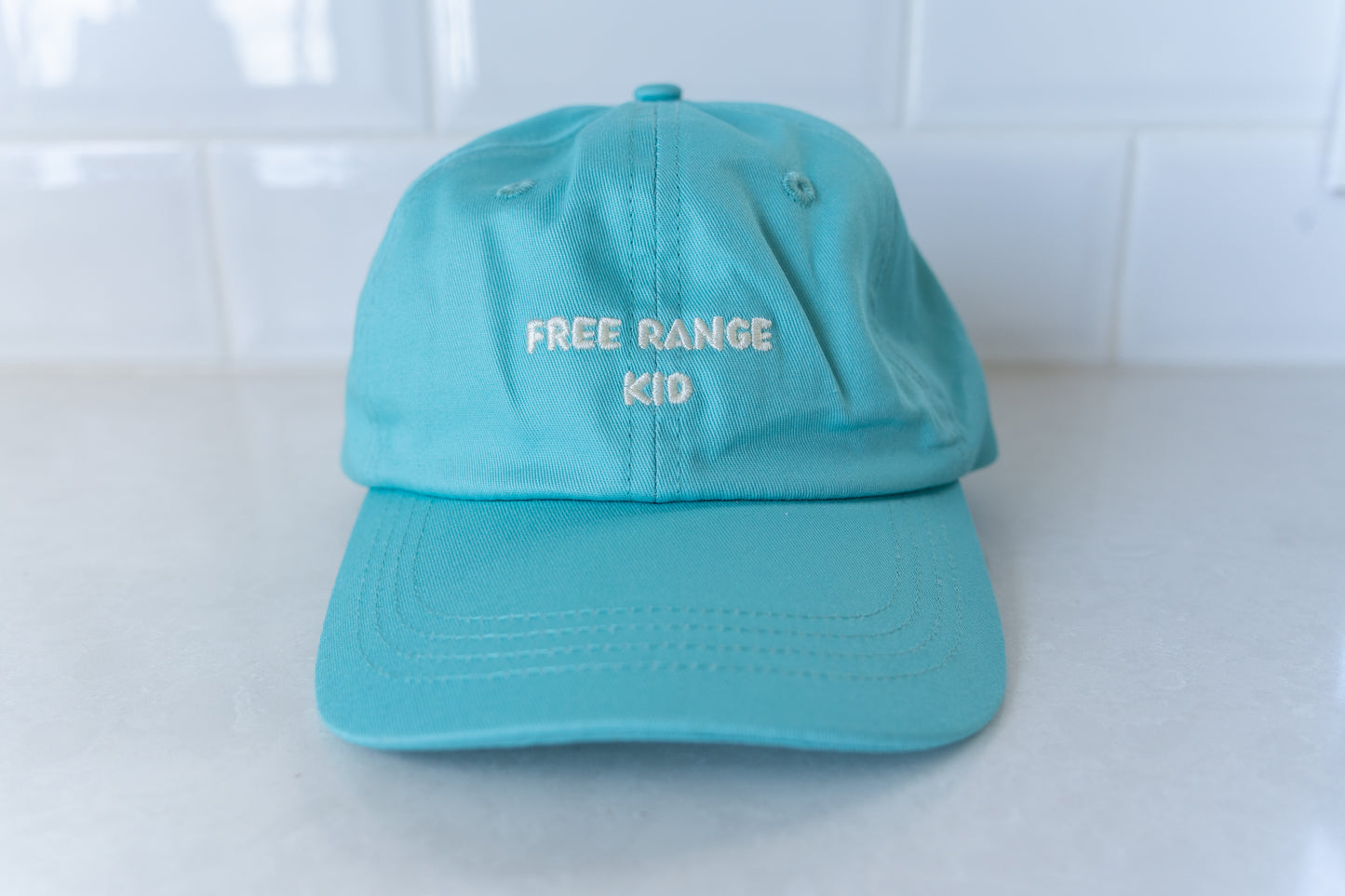 Kids' hat with 'Free Range Kid' text, perfect for adventurous children who love the outdoors.