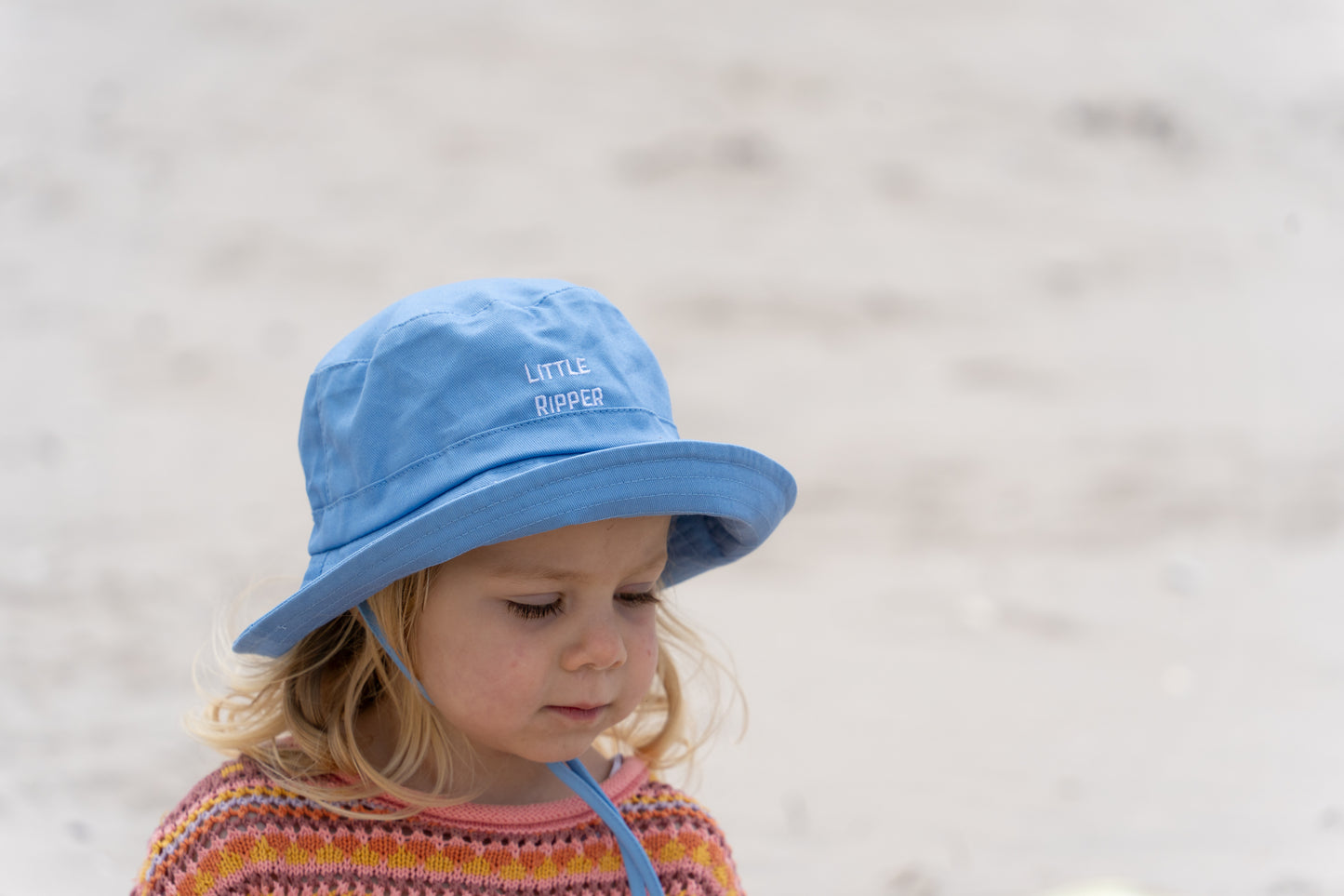 Side view of kids' blue 'Little Ripper' bucket hat, showing adjustable fit and soft fabric, ideal for toddlers and young children.