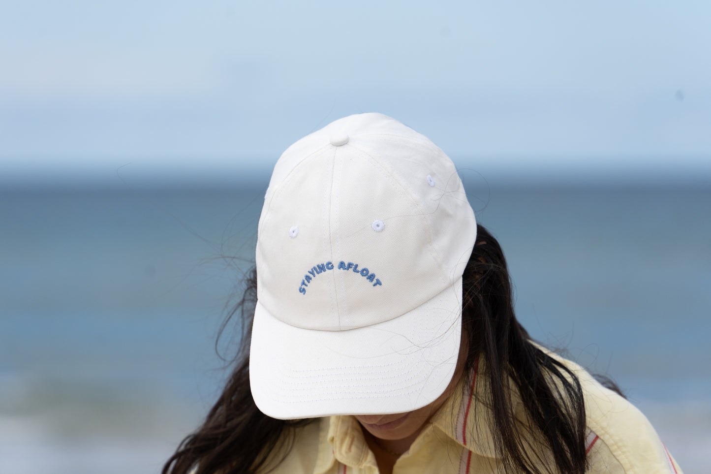 Trendy white 'Staying Afloat' hat for parents, combining comfort and a fun, carefree vibe.