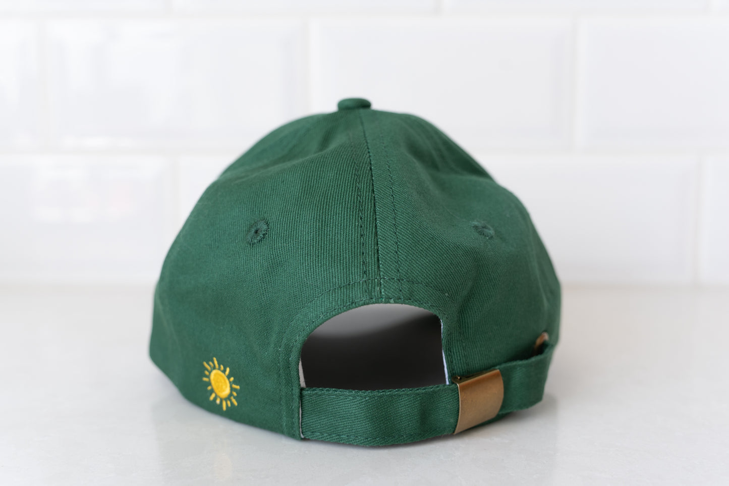 Adult dark green hat with 'Thriving Surviving' slogan, ideal for parents embracing balance and strength.