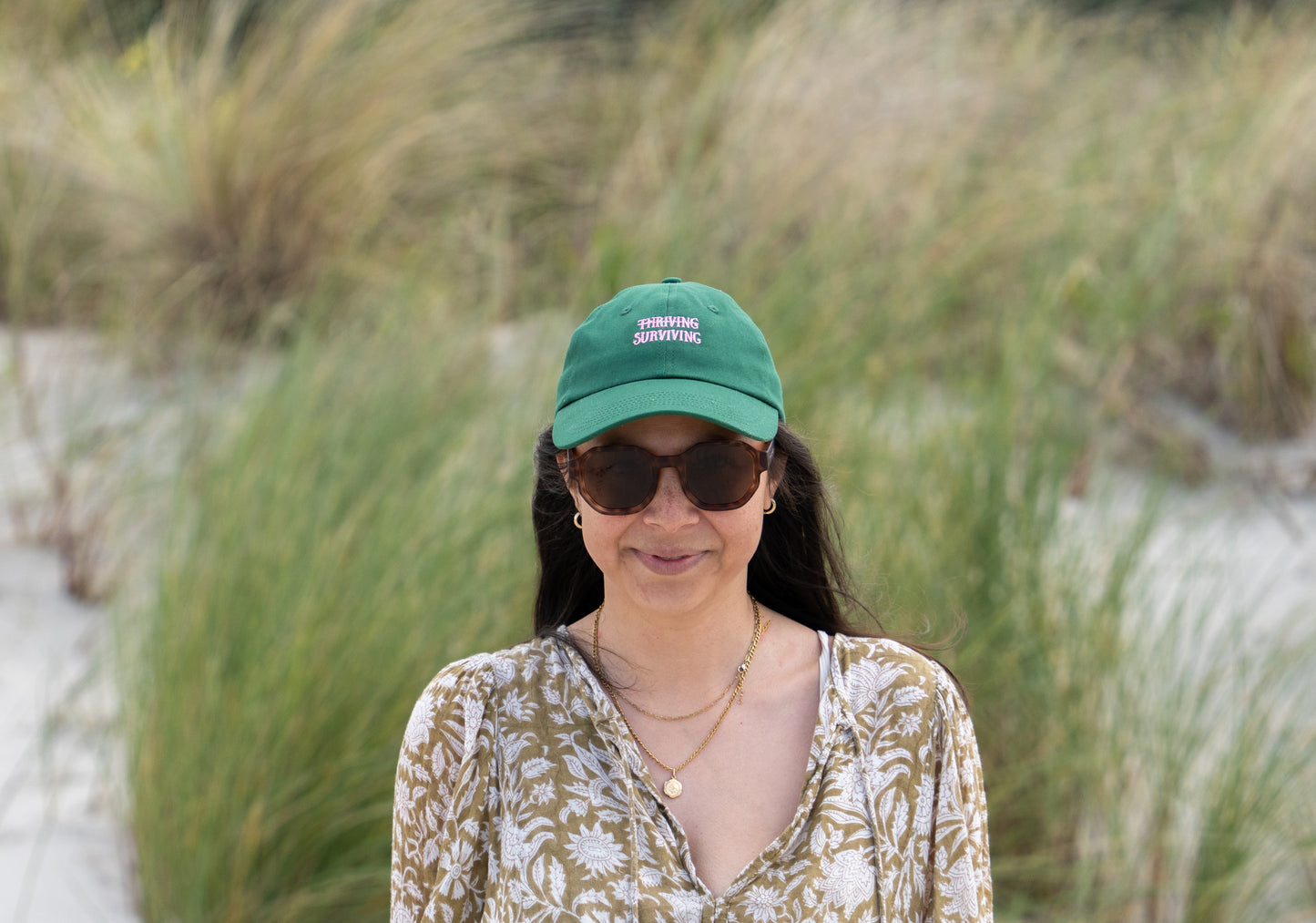 Dark green 'Thriving Surviving' parent hat, combining comfort and a positive, motivational message.