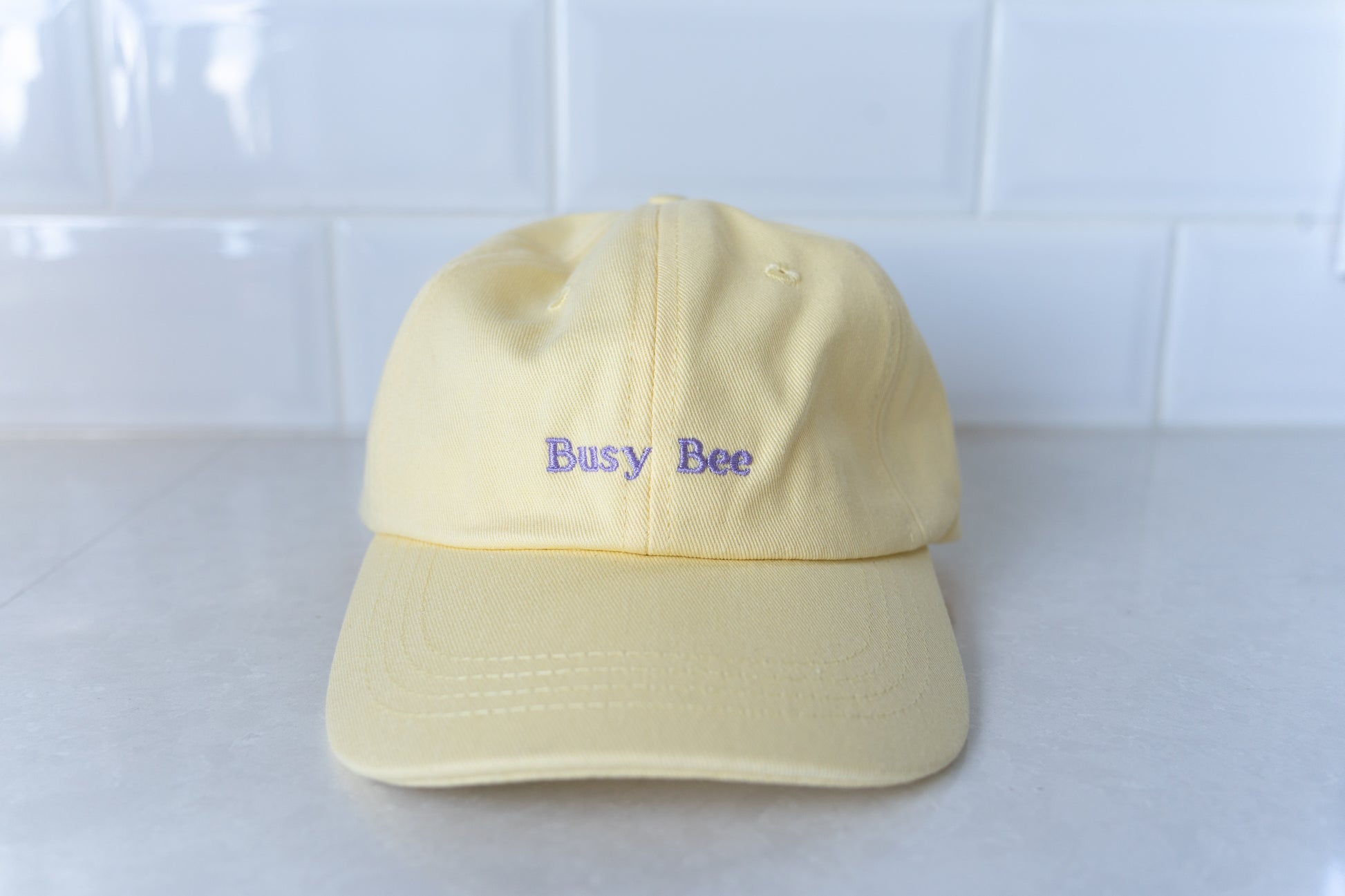 Yellow kids' hat with 'Busy Bee' embroidery, perfect for active children and outdoor play.