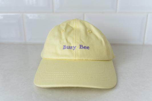 Yellow kids' hat with 'Busy Bee' embroidery, perfect for active children and outdoor play.