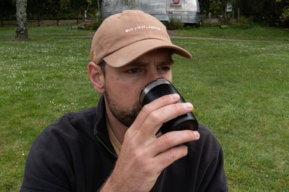Brown 'But First, Coffee' cap for caffeine lovers, minimalist design on a dad hat style.