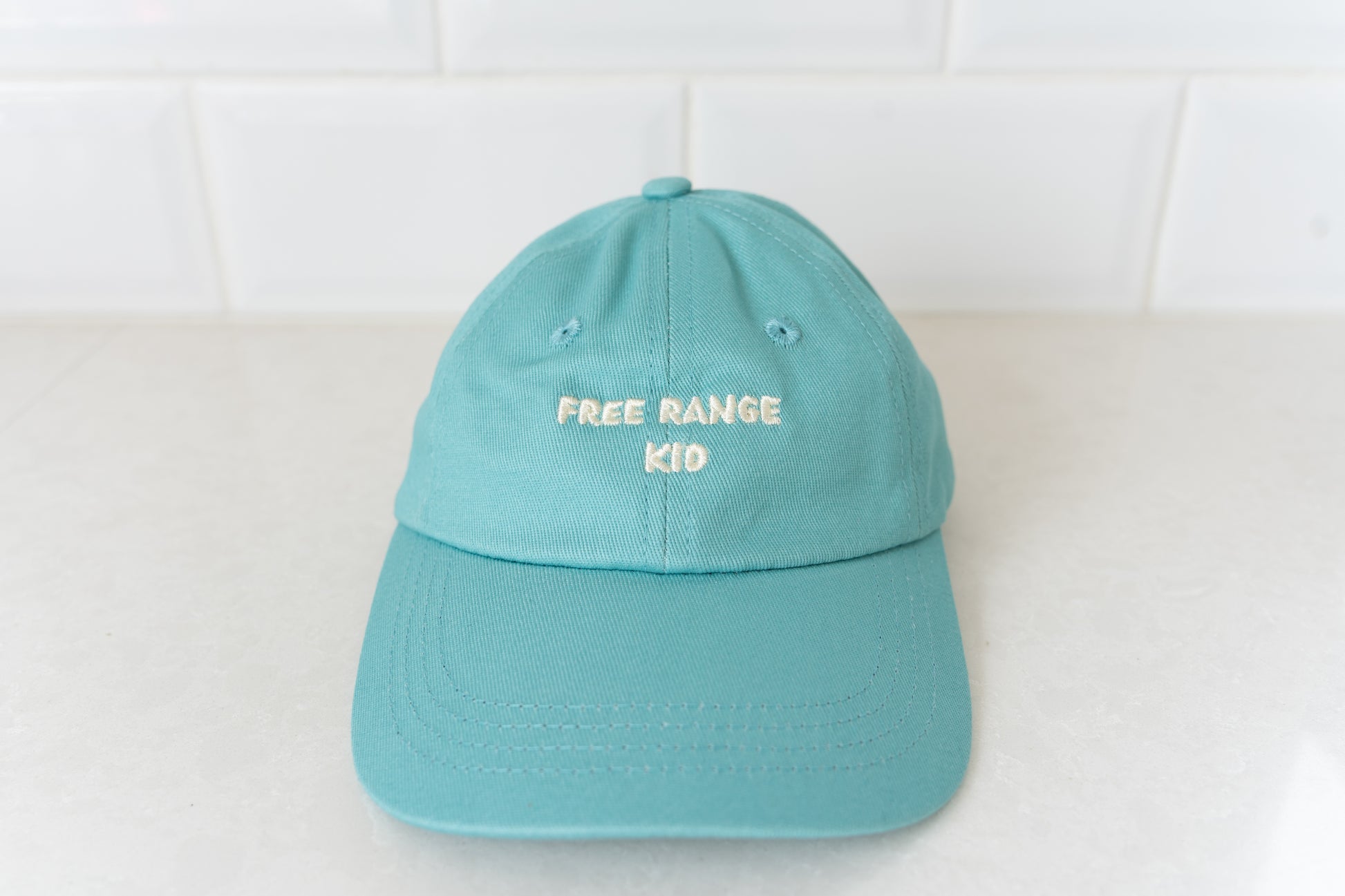 Kids' hat with 'Free Range Kid' text, perfect for adventurous children who love the outdoors.