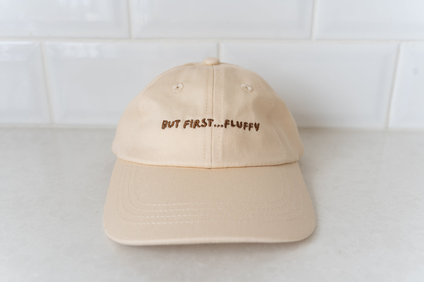 Kids' hat with 'But First, Fluffy' text, perfect for little ones who love fluffies.