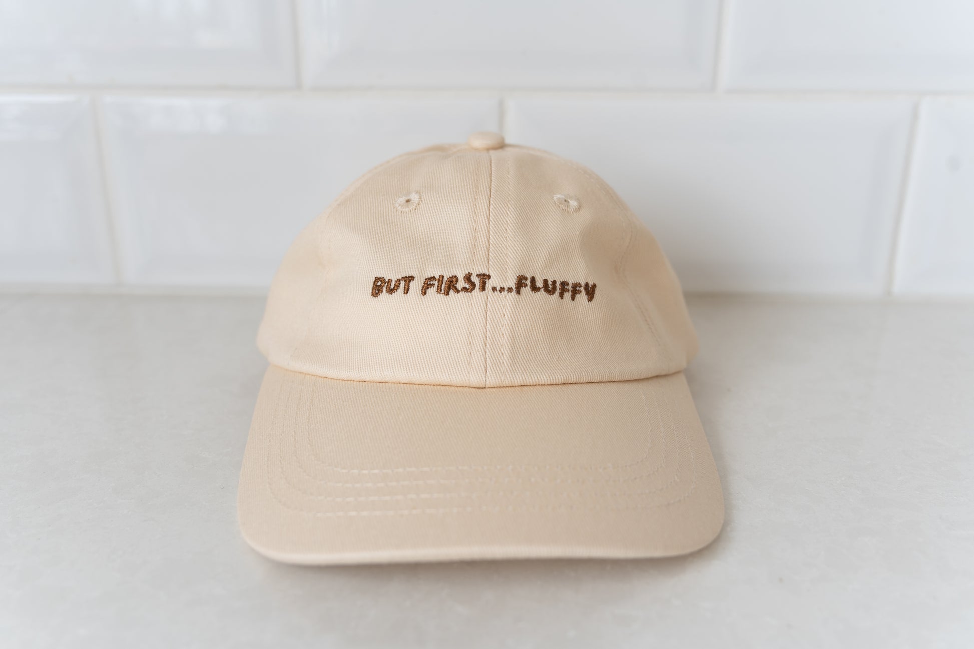 Kids' hat with 'But First, Fluffy' text, perfect for little ones who love fluffies.