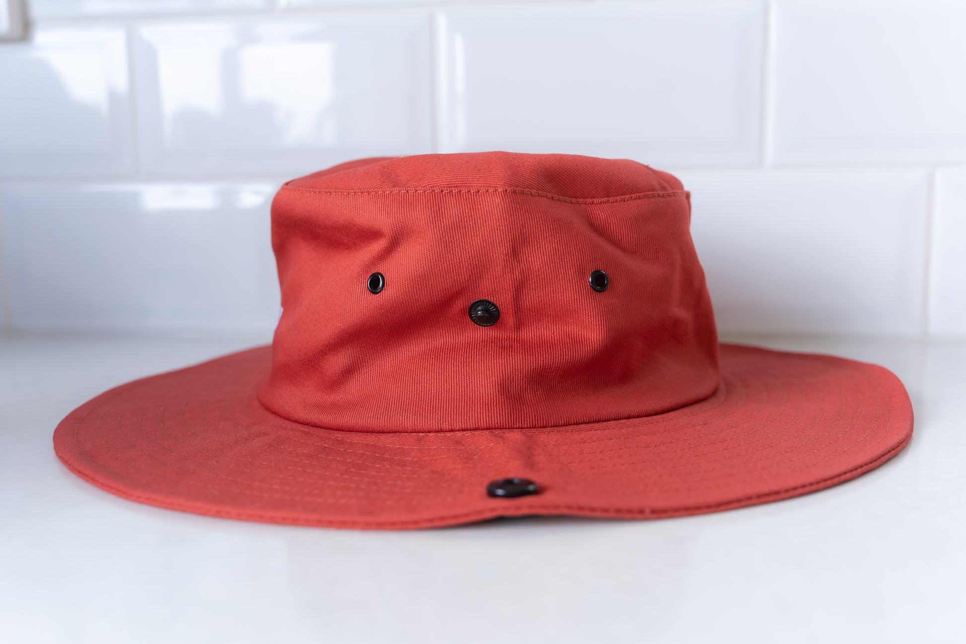 Red 'No Hat No Play' bucket hat for adults, designed for stylish sun safety on sunny days.