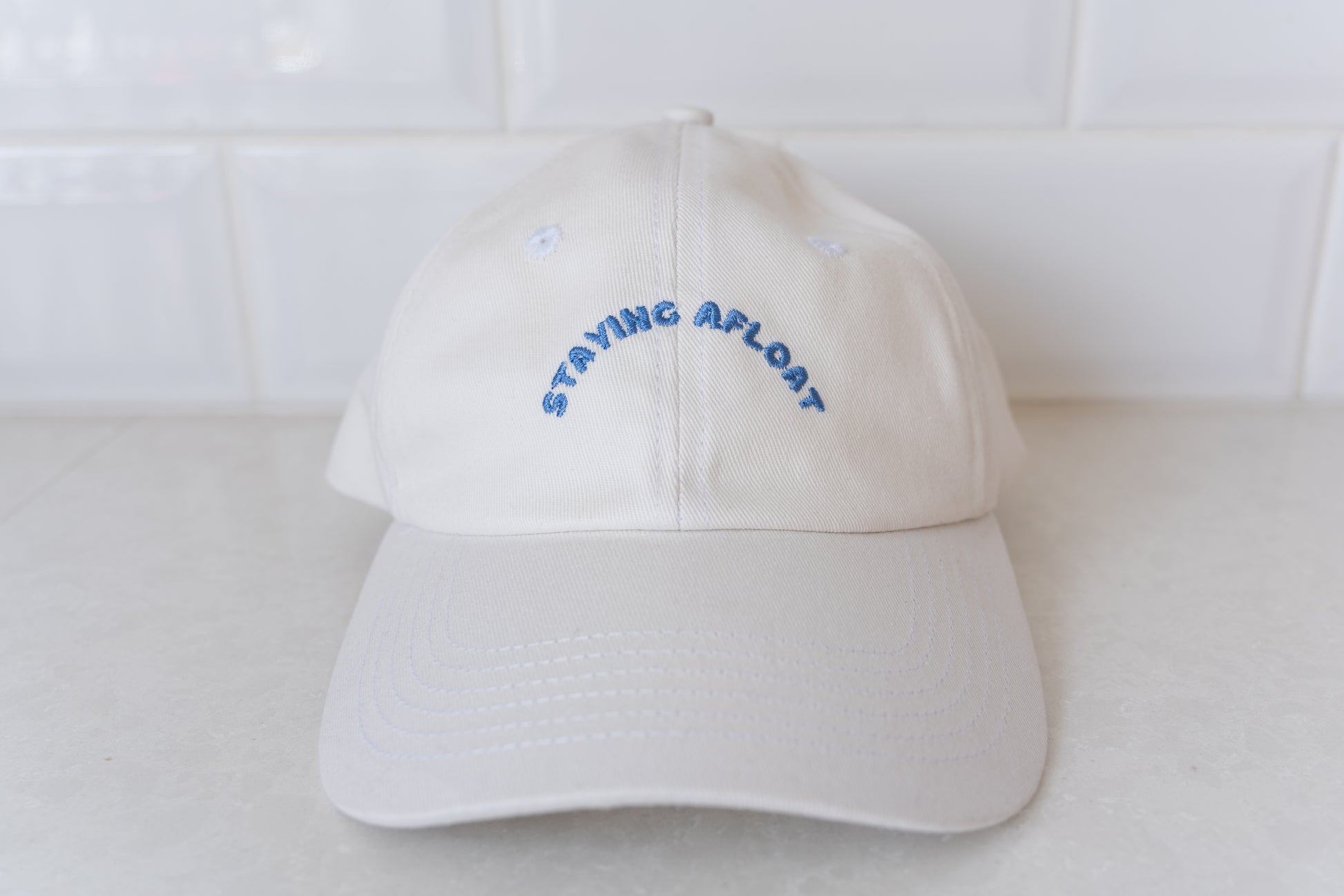 White 'Staying Afloat' hat for adults, perfect for stylish sun protection and casual wear.